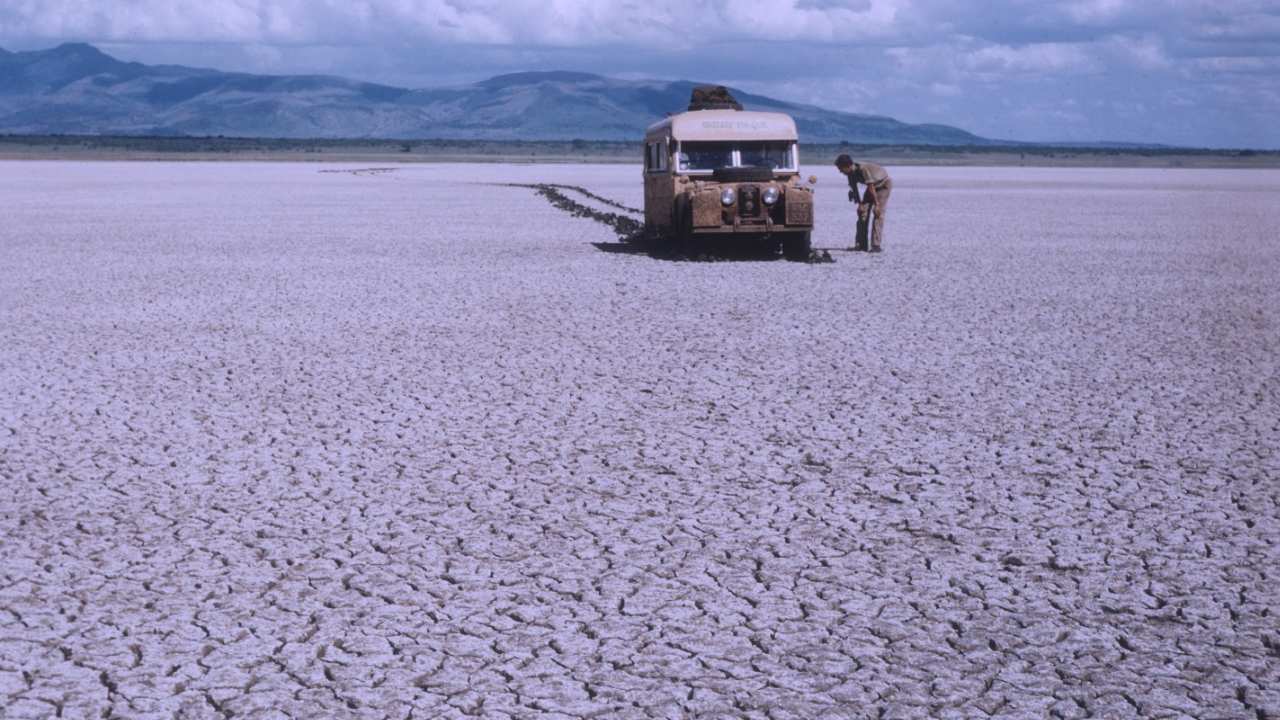 a man looking at a bus in the desert
